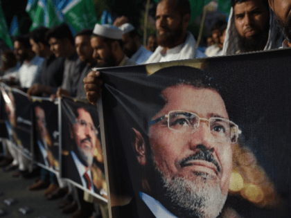 Activists of Jamaat-e-Islami hold pictures of former Egyptian President Mohamed Morsi duri