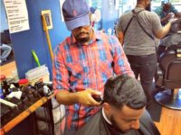 Percy Craig cuts a customer’s hair.