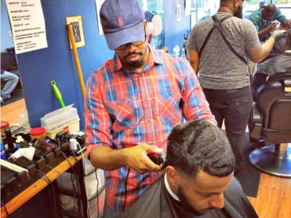 Percy Craig cuts a customer’s hair.