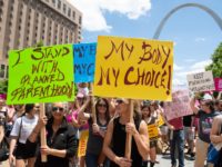 Protesters hold signs as they rally in support of Planned Parenthood and pro-choice and to protest a state decision that would effectively halt abortions by revoking the center's license to perform the procedure, near the Gateway Arch in St. Louis, Missouri, May 30, 2019. (Photo by SAUL LOEB / AFP) …