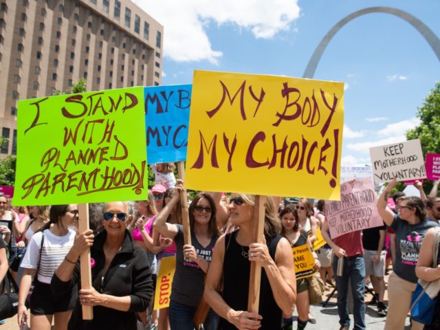 Protesters hold signs as they rally in support of Planned Parenthood and pro-choice and to