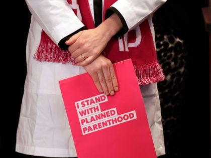 Dr. Erin Berry, Washington State Medical Director for Planned Parenthood of the Great Northwest and the Hawaiian Islands, holds a folder as she listens at a news conference announcing a lawsuit challenging the Trump administration's Title X "gag rule" Monday, Feb. 25, 2019, in Seattle. The rule issued last Friday …