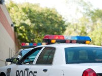 Illuminate flashing lights atop police car during daylight - stock photo