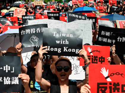 Protesters display placards during a demonstration in Taipei on June 16, 2019, in support of the continuing protests taking place in Hong Kong against a controversial extradition law proposal. - Tens of thousands of people rallied in central Hong Kong on Sunday as public anger seethed following unprecedented clashes between …