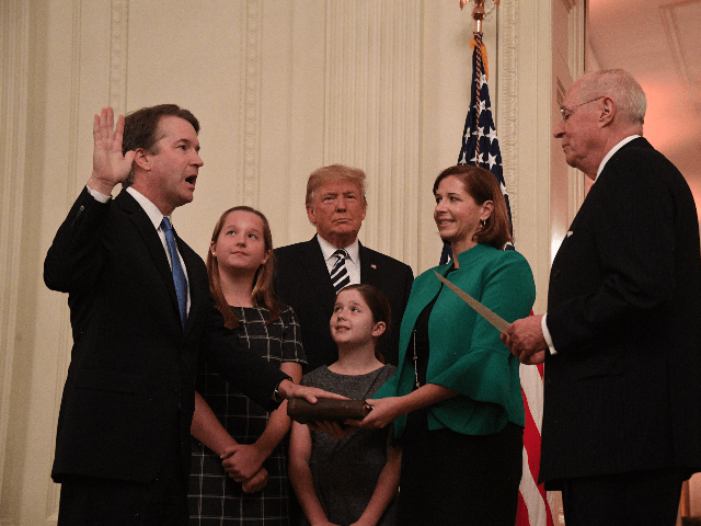 Brett Kavanaugh (L) is sworn-in as Associate Justice of the US Supreme Court by Associate Justice Anthony Kennedy (R) before wife Ashley Estes Kavanaugh (2nd-R), daughters Margaret (2nd-L) and Elizabeth (C), and US President Donald Trump on October 8, 2018 at the White House in Washington, DC. (Photo by Jim …