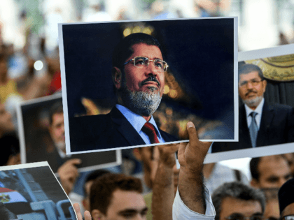 People hold picture of Egyptian President Mohamed Morsi during a symbolic funeral cerenomy on June 18, 2019 at Fatih mosque in Istanbul. - Thousands joined in prayer in Istanbul on Tuesday for former Egyptian president Mohamed Morsi who died the previous day after collapsing during a trial hearing in a …