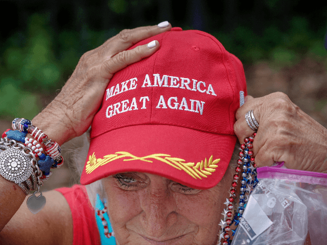 An elderly supporter of US President Donald Trump adjusts her cap as she waits along one o