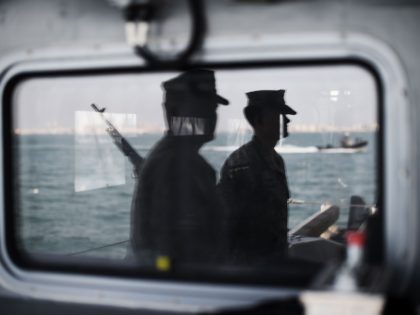 A picture taken of a reflection in the window on April 9, 2016 shows US Navy sailors aboard a ship during the International Mine Countermeasures Exercise (IMCMEX) organised by the US Navy at its Naval Support Activity base, the 5th Fleet command center, in the Bahraini capital Manama. / AFP …