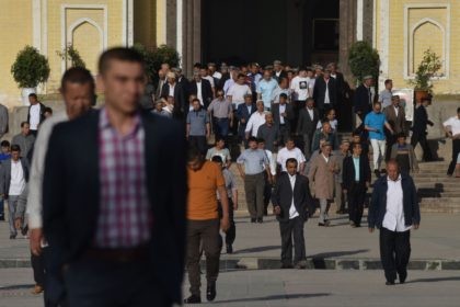 Uighur men leave after Eid al-Fitr prayers, marking the end of Ramadan, at the Id Kah mosq