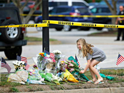 A girl leaves flowers at a makeshift memorial at the edge of a police cordon in front of a municipal building that was the scene of a shooting, Saturday, June 1, 2019, in Virginia Beach, Va. DeWayne Craddock, a longtime city employee, opened fire at the building Friday before police …