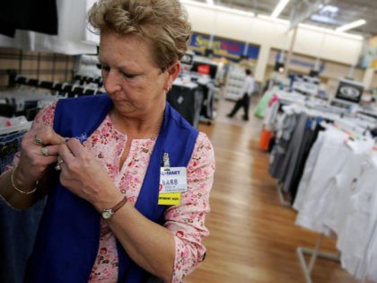BOWLING GREEN, OH - MAY 17: Barbara Kokensparger, who has been working with Wal-Mart for the past 11 years, clips a pin to her work vest inside the new 2,000 square foot Wal-Mart Supercenter store May 17, 2006 in Bowling Green, Ohio. The new store, one of three new supercenters …