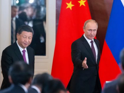 Russian President Vladimir Putin, right, and Chinese President Xi Jinping arrive to attend