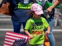 A child with an anti-LGBTQ evangelical Christian group wears an anti-abortion shirt and carries an American flag during the annual LA Pride Parade in West Hollywood, California, on June 9, 2019. - LA Pride began on June 28, 1970, exactly one year after the historic Stonewall Rebellion in New York …