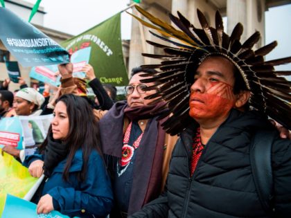 Indigenous leaders from Latin America, Indonesia and Africa, known as "The Guardians of the Forest", display placards during a protest in front of Berlin's Brandenburg Gate on November 1, 2017. At R is a member of Brazil's amazonian Tuxa tribe. The demonstrators, on their way to the COP23 UN Climate …