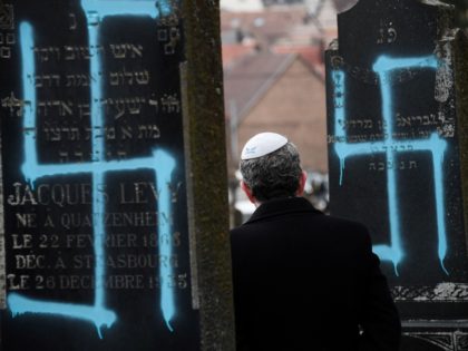 Jews - A man walks by graves vandalised with swastikas at the Jewish cemetery in Quatzenheim, on February 19, 2019, on the day of a nationwide marches against a rise in anti-Semitic attacks. - Around 80 graves have been vandalised at the Jewish cemetery in the village of Quatzenheim, close …