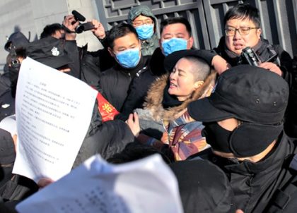 Chinese police and security personnel surround Li Wenzu, wife of human rights lawyer Wang Quanzhang, as she protests the criminal justice system on Dec. 28. (Nicolas Asfouri/AFP/Getty Images)