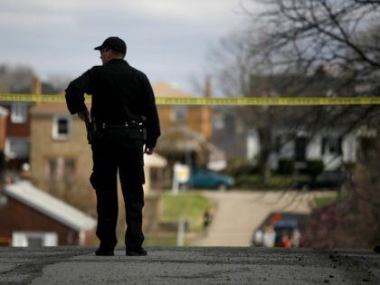 A police officer watches over the crime scene from a nearby corner April 4, 2009 in Pittsburgh, Pennsylvania. Five police officers were shot during a standoff with a suspect in the Stanton Heights neighborhood of Pittsburgh, after police responded to a domestic dispute. (Photo by Ross Mantle/Getty Images)