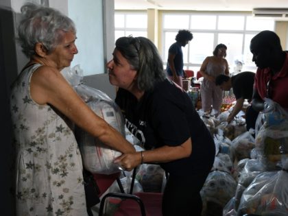 A volunteer comforts an elderly woman at Rio de Janeiro's state public servants union as she gives her a food and supplies donation prepared by workmates and volunteers, since some of them haven't received their payment for several months, in Rio de Janeiro, Brazil on December 27, 2016. Rio de …