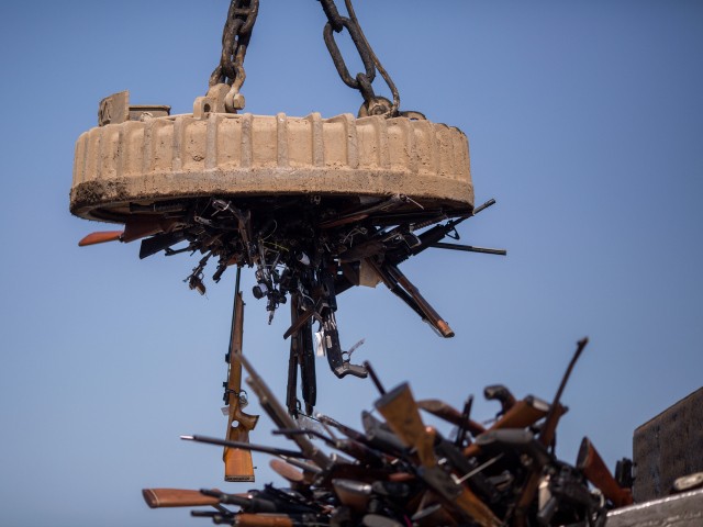 An electromagnet is used to pick up some of approximately 3,500 confiscated guns to be melted down at Gerdau Steel Mill on July 19, 2018 in Rancho Cucamonga, California. The weapons were seized in criminal investigations, probation seizures and gun buyback events, and will be recycled into steel rebar for the construction of highways and bridges. (Photo by David McNew/Getty Images)