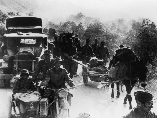May 1941: A German military convoy overtakes a group of Greek peasants on a rural track du