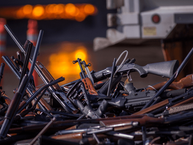 Molten slag is seen behind a pile of approximately 3,500 confiscated guns about to be destroyed at the Gerdau Steel Mill understand supervision of the Los Angeles County Sheriffs Department and other law enforcement agencies on July 19, 2018 in Rancho Cucamonga, California. The weapons were seized in criminal investigations, probation seizures and gun buyback events, and will be recycled into steel rebar for the construction of highways and bridges. (Photo by David McNew/Getty Images)