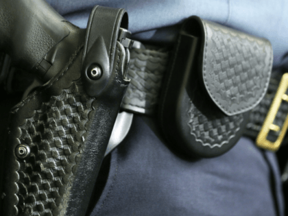 A handgun sits in the holster that belongs to a law enforcement officer during a news conf