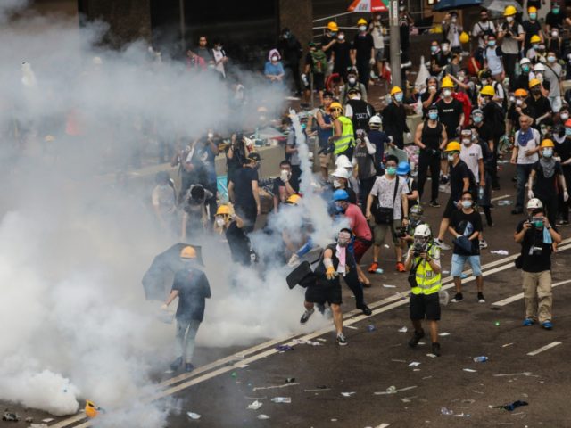A protester throws a tear gas canister fired by police during a rally against a controversial extradition law proposal outside the government headquarters in Hong Kong on June 12, 2019. - Violent clashes broke out in Hong Kong on June 12 as police tried to stop protesters storming the city's …