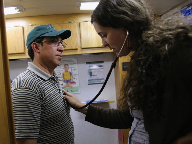 Physician's assistant Stephanie Miller checks the heart rate of an immigrant farm worker f