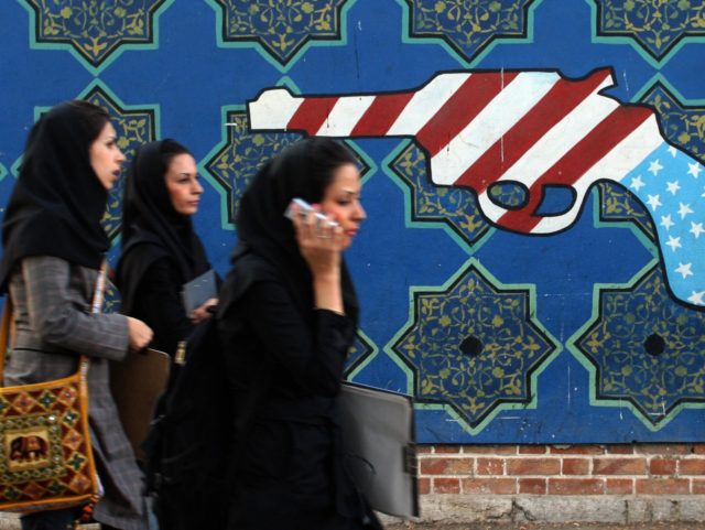 TO GO WITH AFP STORY BY STUART WILLIAMS: Iranian students walk past an anti-US mural on th
