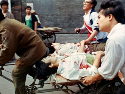 FILE - In this June 4, 1989 file photo, a rickshaw driver peddles wounded people, with the