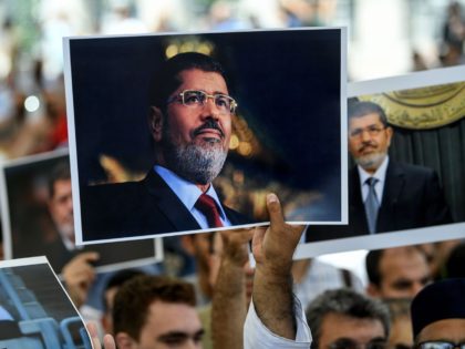 People hold picture of Egyptian President Mohamed Morsi during a symbolic funeral cerenomy