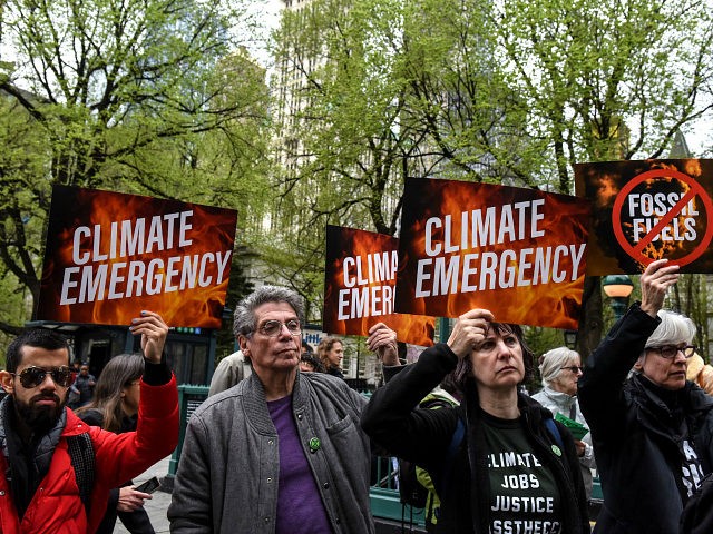 NEW YORK, NY - APRIL 17: People hold sign saying "climate emergency" while participating i