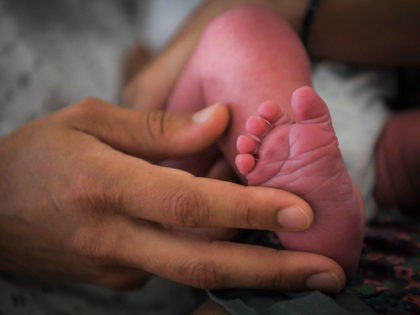 A mother holds the foot of her newborn baby on July 7, 2018 at the hospital in Nantes, wes