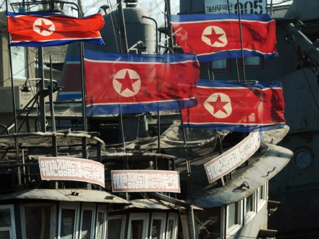 North Korean flags fly at half-mast on fishing boats after the funeral of the late leader