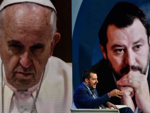 Italys Interior Minister and Deputy Prime Minister Matteo Salvini gestures as he speaks during the Italian talk show "Porta a Porta", broadcast on Italian channel Rai 1, in Rome, on June 20, 2018, as a picture of Pope Francis is seen in the background. (Photo by Andreas SOLARO / AFP) …