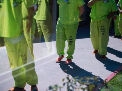 Men wearing neon-colored jail clothes signifying immigration detainees walk to pick up their lunches at the Theo Lacy Facility, a county jail which houses convicted criminals as well as immigration detainees, March 14, 2017 in Orange, California, about 32 miles (52km) southeast of Los Angeles. US President Donald Trumps first …