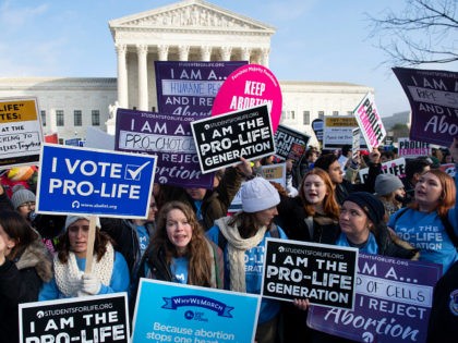 Pro-choice activists hold signs in response to anti-abortion activists participating in the "March for Life," an annual event to mark the anniversary of the 1973 Supreme Court case Roe v. Wade, which legalized abortion in the US, outside the US Supreme Court in Washington, DC, January 18, 2019. (Photo by …