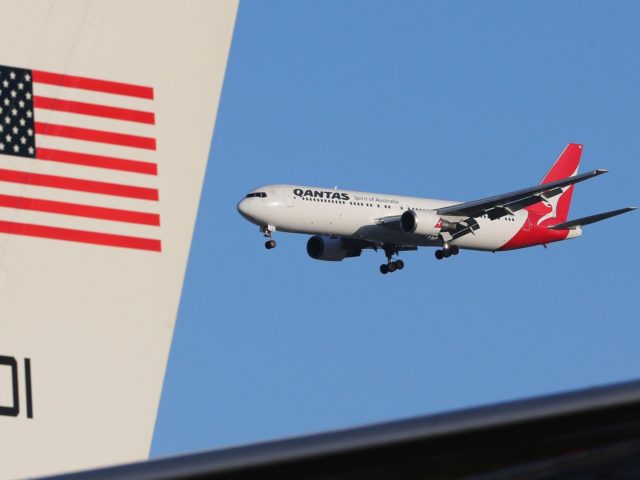 A QANTAS jet flies past the plane of U.S. Secretary of State John Kerry before departing o
