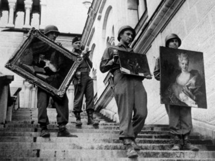 May 1945: US soldiers carrying some of the priceless collection of paintings discovered in an Austrian castle. The Nazi loot was intended to go into a huge art gallery at Linz, in a plan devised by Goering. (Photo by Keystone/Getty Images)