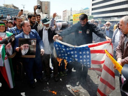 Iranian demonstrators burn a makeshift US flag during a rally in the capital Tehran, on May 10 2019. - Iranian foreign minister blamed the EU for the decline of Tehran's nuclear accord with world powers and insisted the bloc "should uphold" its obligations under the pact in which Iran agreed …