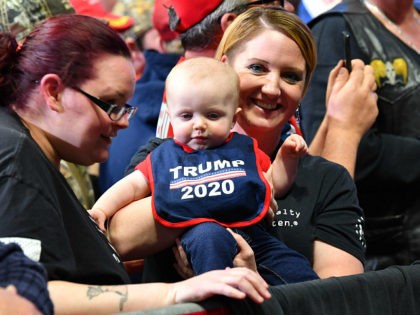 A supporter of the US president holds a baby wearing a "Trump 2020" bib as she attends a campaign rally in Grand Rapids, Michigan on March 28, 2019. (Photo by Nicholas Kamm / AFP) (Photo credit should read NICHOLAS KAMM/AFP/Getty Images)