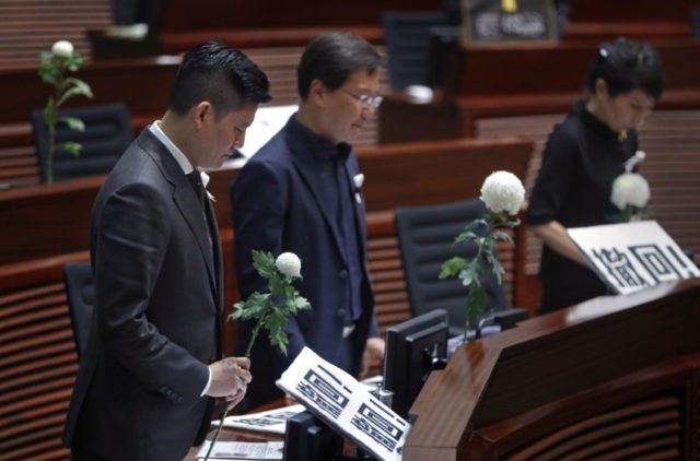 Hong Kong Protests Pro democracy lawmakers pay a silent tribute to the man who fell to his death on Saturday evening after hanging a protest banner on scaffolding on a shopping mall, at the Legislative Council in Hong Kong, Wednesday, June 19, 2019. Hong Kong lawmakers are meeting for the first time in a week, after massive protests over an extradition bill that eventually was suspended.(AP Photo/Vincent Yu) The Associated Press