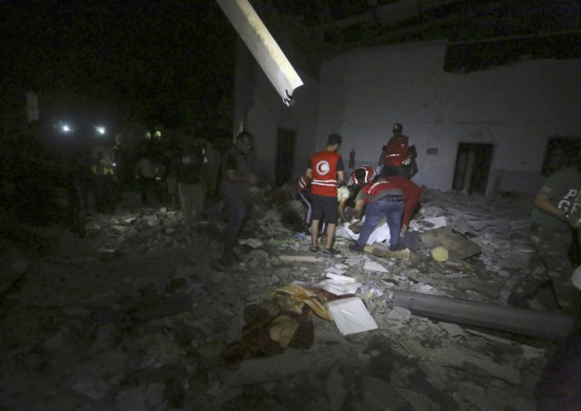 Libyan Red Crescent workers recover migrants bodies after an airstrike at a detention cent