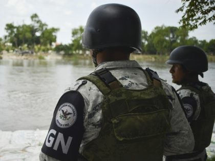 Mexican National Guards (GN) stand on the bank of the Suchiate River during a press tour o