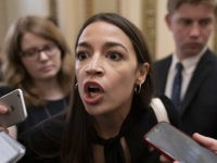 Rep. Alexandria Ocasio-Cortez, D-N.Y., a target of racist rhetoric from President Donald Trump, responds to reporters as she arrives for votes in the House, at the Capitol in Washington, Thursday, July 18, 2019. (AP Photo/J. Scott Applewhite)