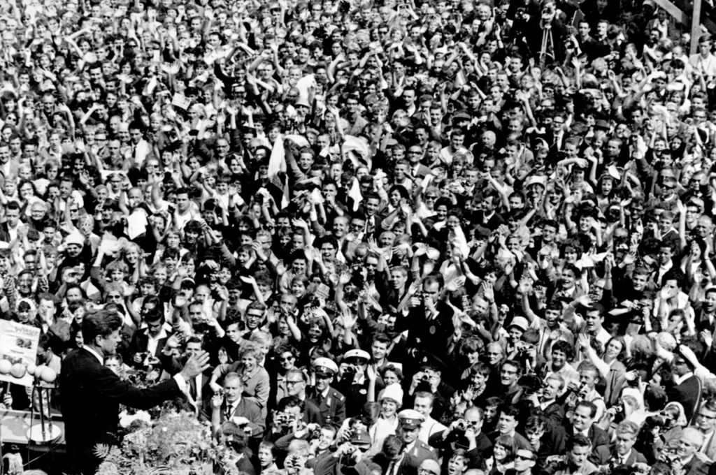 FILE - In this June 26, 1963 file photo, U.S. President John F. Kennedy, left, waves to a crowd of more than 300,000 gathered to hear his speech in the main square in front of Schoeneberg City Hall in then West Berlin. Berlin is celebrating Wednesday, June 26, 2013 the 50th anniversary of President John F. Kennedy's famed "Ich bin ein Berliner" speech  a pledge of support to the divided city on the Cold War's front line that still resonates in a much-changed world. (AP Photo, File)