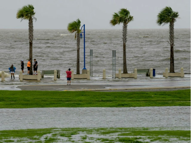 People check out the waves on Lakeshore Drive in New Orleans, Friday, July 12, 2019, as wa