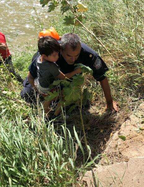 A CBP supervisory officer helps rescue a migrant toddler after his father tried to bring him across the swiftly moving Rio Grande. (Photo: U.S. Border Patrol/Rio Grande Valley Sector)