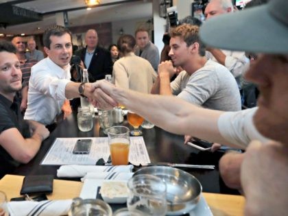 Democratic presidential candidate South Bend Mayor Pete Buttigieg shakes hands with a patron at the Revolution Taproom & Grill as he campaigns, Friday, July 12, 2019, in Rochester, N.H. (AP Photo/Charles Krupa)