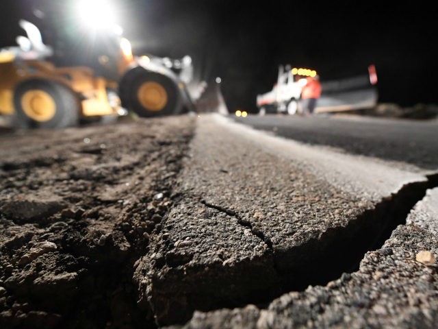 Highway workers repair a hole that opened in the road as a result of the July 5, 2019 earthquake, in Ridgecrest, California, about 150 miles (241km) north of Los Angeles, early in the morning on July 6, 2019. - Southern California was hit by its largest earthquake in two decades …